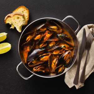 freshly cooked mussels in a frying pan in tomato sauce. pepata d